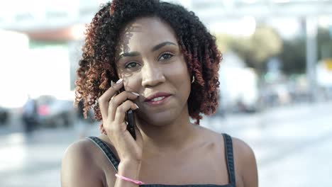 Front-view-of-cheerful-woman-talking-with-friend-through-phone